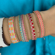 Pulsera Kenia Hecha a Mano en Tonos Rosa, Rojo y Dorado