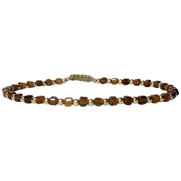 Esta pulsera está hecha a mano por nuestro equipo de maestras artesanas usando bolitas de oro 14k gold filled y piedras de Hessonita. Un diseño elegante y chic para las mujeres más estilosas.   Detalles:      Piedra Hessonita     Bolitas de oro 14k gold filled      Hecho a mano      Pulsera ajustable, que se adapta a cualquier tipo de muñeca.      Anchura 3 mm     Se puede mojar